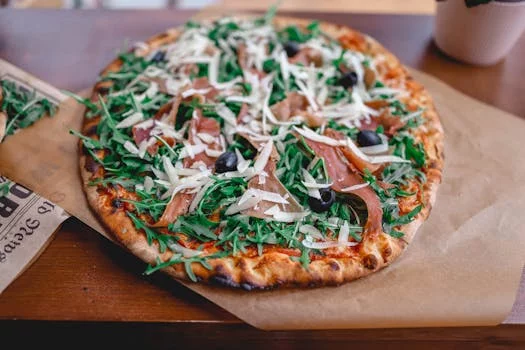 gourmet pizza with prosciutto and arugula